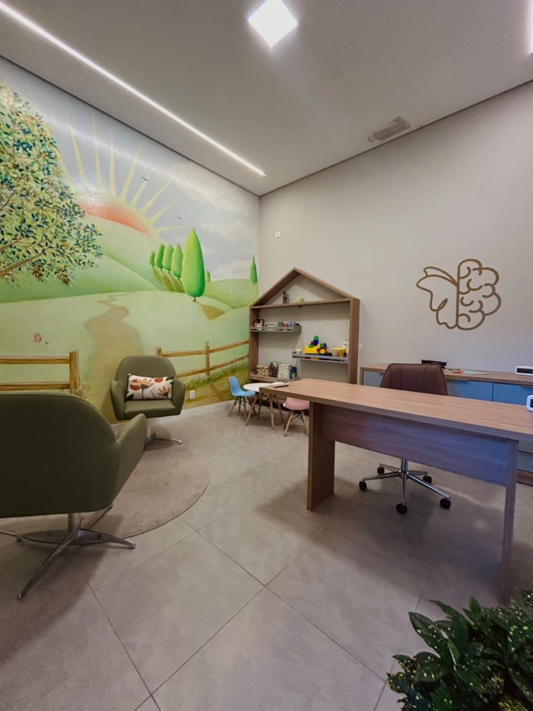 Sala infantil com mural, mesa e estante