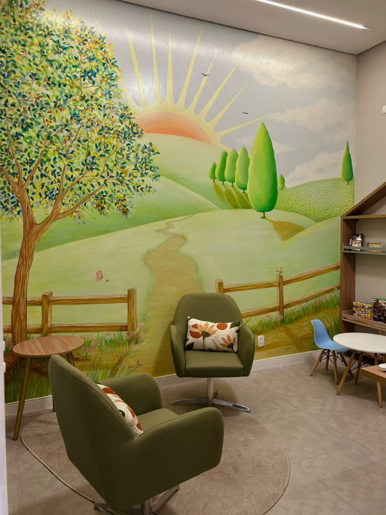 Sala infantil com mural e poltronas verdes